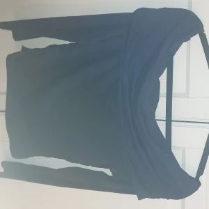 Mörkblå offshoulder topp från Gina Tricot - Säljer en stilren mörkblå offshoulder topp från Gina Tricot. Toppen har långa ärmar och en elegant design som passar perfekt för olika tillfällen. Perfekt för dig som vill ha en trendig och bekväm look.