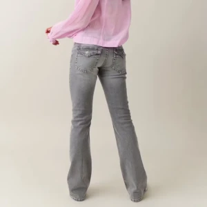 Grå bootcut jeans - Snygga grå bootcut jeans med knappar och dragkedja. De har en klassisk femficksdesign och är perfekta för en avslappnad stil. Passar bra till både sneakers och klackar. Knappt använda då de är för korta