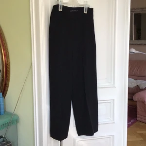 Svarta eleganta byxor från Zara Woman - Snygga svarta festliga byxor från Zara Woman med hög midja och rak passform. Perfekta mycket eleganta för en stilren look. Tillverkade i ett mjukt och bekvämt material som ger en elegant känsla.