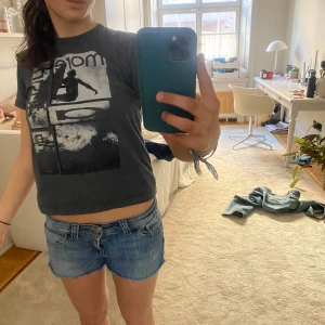Blå jeansshorts från Lee - Säljer ett par snygga blå jeansshorts från Lee med fransiga kanter. Perfekta för sommardagar och har en klassisk femficksdesign. De är lågmidjade och har en knapp- och dragkedjestängning framtill.