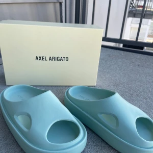 Ljusblå sandaler från Axel Arigato - Oanvända snygga ljusblå/gråa sandaler från Axel Arigato med en modern design. De har en öppen tå och är tillverkade för att vara chunky och bekväma. Perfekta för en avslappnad stil eller till sommaren för att slippa ta med sneakersen till stranden.             Nypris: 2600kr
