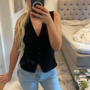 Svart väst med knappar - Säljer en jätte fin topp från Gina, helt oanvänd och fin. Passar bra till jeans eller kjol.❤️