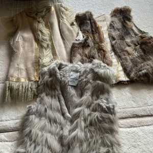 Tre pälsvästar i olika stilar - Säljer tre snygga pälsvästar. En beige med gulddetaljer och fransar, en brunmönstrad och en grå från Aj117 Project. Perfekta för att ge din outfit en extra touch. Fit an small - medium 