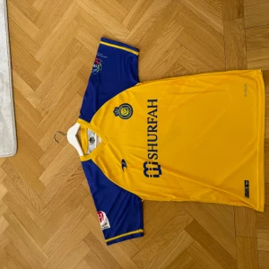 Al Nassr tröja med Ronaldo på ryggen - Säljer en Al Nassr tröja från 22/23 säsongen. Den är i mycket bra skick och säljs för väldigt bra pris. Ronaldo på ryggen