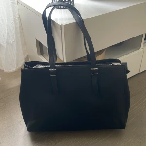 Perfekta skolväskan från Don Donna❤️ - Snygg svart axelväska från Don Donna i syntetmaterial. Väskan har flera fack med dragkedja och justerbara axelremmar. Perfekt för att organisera dina saker med stil. En klassisk och praktisk väska för alla tillfällen. Inga defekter alls😁 Tryck ej köp nu