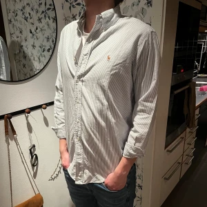 Ralph Lauren skjorta - Ralph Lauren skjorta i lite annorlunda fit. Storlek L. Modellen är ca 185 cm lång. En fläck vid armen Vid frågor eller funderingar är det bara att skriva! 