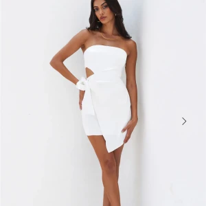 Vit axelbandslös klänning - Snygg vit axelbandslös klänning med knytning i midjan. Skulle blivit min studentklänning egentligen, såå fin🥰 köpt på hellomolly för 1200kr. Aldrig använd och lapparna är kvar.