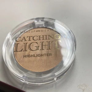 Catching Light Highlighter från Makeup Mekka - Snygg highlighter från Makeup Mekka i nyansen 'Beam Time'. Den kommer i en praktisk rund förpackning med genomskinligt lock. Perfekt för att ge ansiktet en strålande glöd.