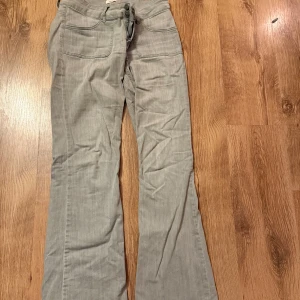 Grå bootcut jeans - Snygga grå byxor med fickor fram och bak. Byxorna har en bootcut-stil som ger en avslappnad look. Perfekta för en casual outfit.