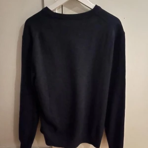 Svart tröja från Maglia Studio - Snygg svart tröja från Maglia Studio, tillverkad i Italien. Tröjan har en klassisk design med långa ärmar och rund hals. Perfekt för en stilren look.