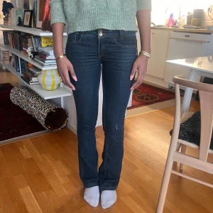 SUPERSNYGGA VINTAGE LOWWAIST JEANS!! - Snygga mörkblå jeans med bootcut och klassisk femficksdesign. De har en knapp och dragkedja framtill. Perfekta för en avslappnad stil.