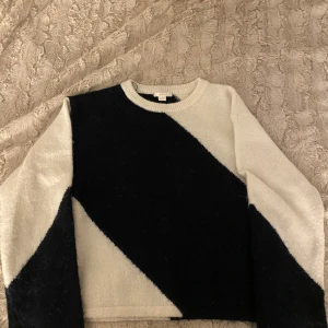 Svart och vit tröja från Gina Tricot - Säljer en snygg mörkblå  och vit tröja från Gina Tricot. Tröjan har ett diagonalt mönster och är långärmad. Perfekt för en stilren look.