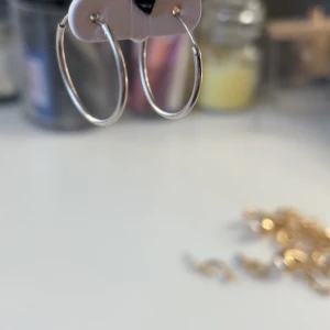 Silverfärgade hoop-örhängen - Snygga och stilrena silverfärgade hoop-örhängen. Perfekta för att ge en elegant touch till din outfit. Enkla att matcha med andra smycken. Säljer pågrund av att jag bytt till guld, köpta för 170kr