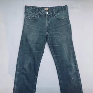Grå jeansbyxor från Morris - Snygga gråa jeansbyxor från Morris  med klassisk  knappgylf. Byxorna har en rak passform och är perfekta för en avslappnad stil. De har en diskret tvättad look som ger en cool touch.             Det står 34 35 men passar mer som ungefär 32 33.