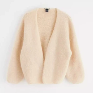 Beige kofta - Säljer denna beiga stickade tröja från Lindex då jag inte använder den längre. Använd flertal gånger och därav lite nopprig men har inga andra defekter. Nypris är 399kr