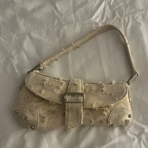 Beige axelväska med slitna detaljer - Säljer en beige axelväska med coola slitna detaljer✨ Perfekt nu till sommaren ☀️🌻
