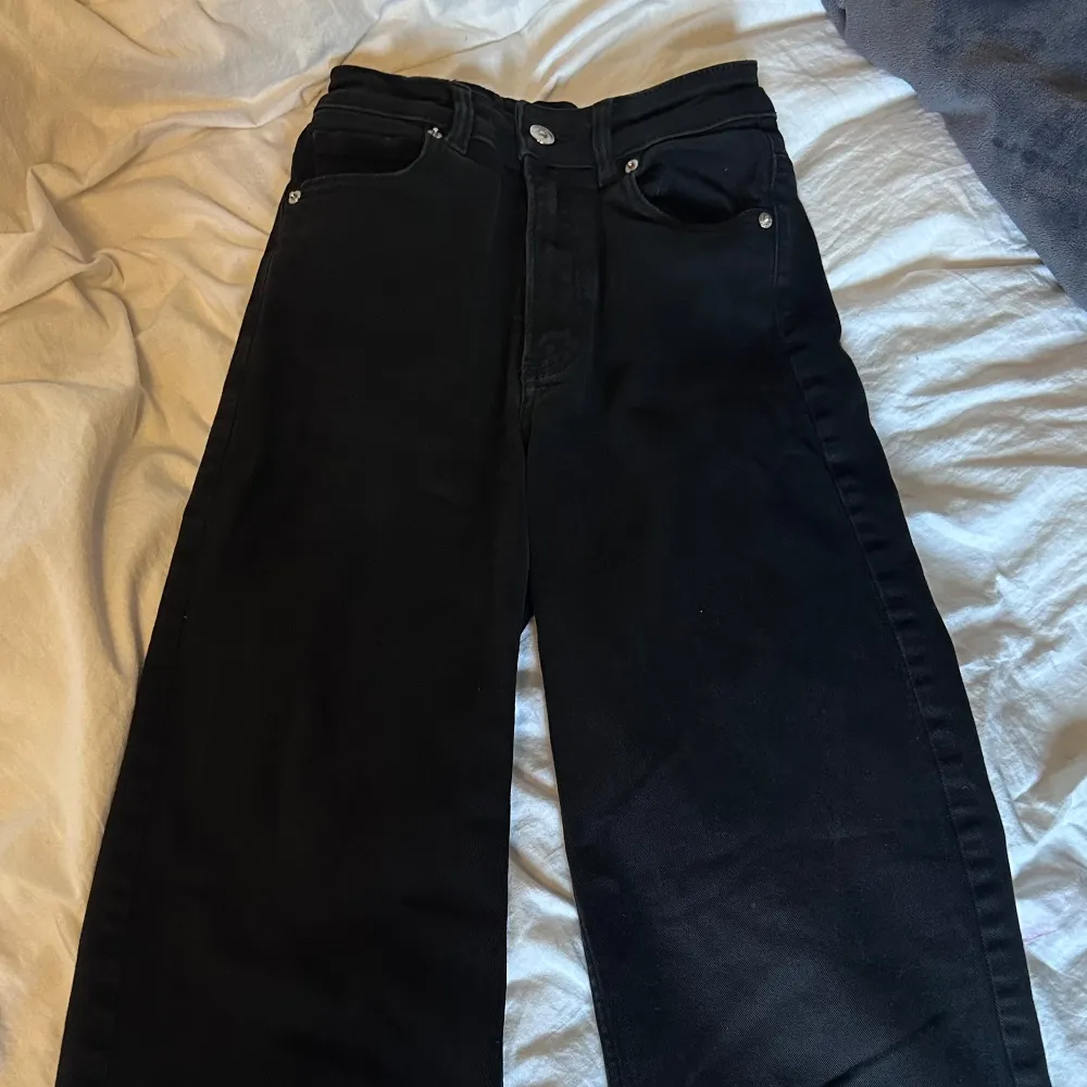 Snygga svarta jeansbyxor med hög midja och raka ben. De har en klassisk femficksdesign och stängs med dragkedja och knapp. Perfekta för en stilren look.. Farkut & Housut.