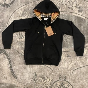 Svart burberry Zip Up Hoddie - Aldrig använt, helt ny skick, size M med passar XS, kom pv för mer info, ge gärna bud
