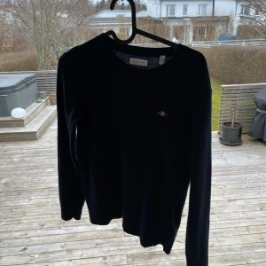 Mörkblå tröja från Gant - Säljer en stilren mörkblå tröja från Gant med rund halsringning. Tröjan har långa ärmar och en liten logotyp på bröstet. Perfekt för en klassisk och tidlös look. Köpt på gant för 800kr säljer min nu för 350kr. Skriv vid minska fundering 😃
