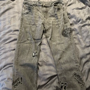Ed Hardy Jeans - Gråa ed Hardy jeans som är i toppen skick! Inga tecken på slit. Säljs då jag knappt använt de sedan jag köpte och hellre köper nått annat!