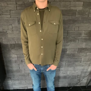 Olivgrön skjorta från Ciszere - Snygg olivgrön skjorta från Ciszere i slim fit. Endast använd fåtal gånger. Perfekt för en stilren look.                                                                       Nypris: ca 1500kr 