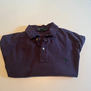 Mörklila pikétröja från Polo Ralph Lauren - Säljer en mörklila pikétröja från Polo Ralph Lauren i storlek XL men passar L. Använd ett fåtal gånger, varan är äkta såklart. Kan mötas i Sthlm eller frakta 🚚 