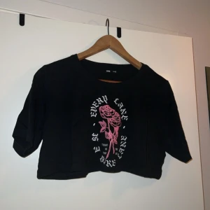 Svart croppad topp med rosor - Svart croppad topp från Sinsay i Polen. 