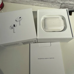 AirPods Pro (2nd generation) etui + vänster hörlur  - Airpods Pro Gen 2 oanvänt etui. Finns en hel hörlur (vänster) plus en trasig om man vill ha med dem. Skalet/eutiet är inköpt oktober 2023 och lurarna januari 2024. Kan skicka serienummer om så önskas. Bara att höra av sig vid frågor! 