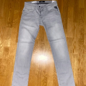 Replay X-Lite+ ljusgrå jeans, strl 30 - Säljer ett par Replay X-Lite+ jeans i en snygg ljusgrå färg. Modellen heter Rocco och har comfort fit, vilket ger en avslappnad känsla. Jeansen är tillverkade i ultralätt denim och har klassiska fickor med Replay-detaljer. Perfekta för dig som gillar stilrena och bekväma jeans.