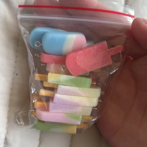 Färgglada glassörhängen i plast - Säljer ett gäng superfina örhängen formade som glasspinnar i olika färger och pastelltoner. Finns i blått, rosa, grönt, gult och lila, alla med coola färgskiftningar. Perfekt för dig som vill ha något unikt och lekfullt till din stil!