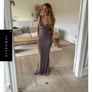 Lång grå klänning Design by Si - Supersnygg lång grå klänning från Design by Si med draperad urringning och öppen rygg. Endast använd 1 gång. 