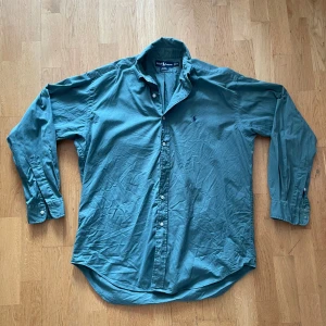 Grön skjorta från Ralph Lauren M - Hej, säljer en väldigt fräsch oliv grön skjorta från Ralph Lauren. Skick 8/10. Färg, grön. Storlek- M. Passar en som är emellan 175-185. Går att förhandla priser! 