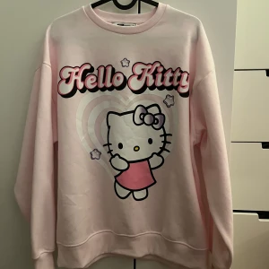 Oversized Hello Kitty rosa sweatshirt H&M - Supergullig oversized rosa sweatshirt från H&M med stort Hello Kitty-tryck framtill och hjärtformad bakgrund. 
