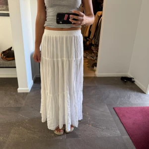 Vit långkjol Stradivarius - Säljer en flowy vit långkjol med flera volanger och elastisk midja. Storlek M men passar även S! Är inte see through! Aldrig använd