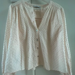 Aprikos blus med prickigt mönster - Jättefin aprikos färgad blus med diskret prickigt mönster. Blusen har långärmade puffärmar och en luftig, croppad passform. Aldrig använd.💖