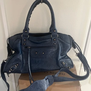 Balenciaga city bag liknande väska  - Intressekoll på denna sååå snygga mörkblå balenciaga city bag liknande väska !! I jättebra skick och är väldigt rymlig ! Perfekt till skolan 💕💕💕 har även en spegel till! Pris kan diskuteras vid snabb affär 