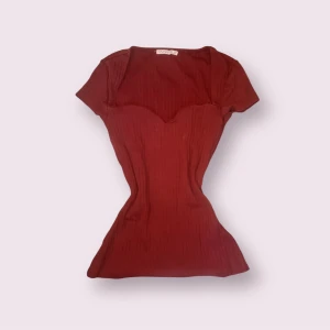 Vinröd ribbad topp från Anna Field - Vinröd topp från Anna Field med korta ärmar och snygg sweetheart-urringning. Ribbad struktur som ger en cool och figurnära passform. Perfekt för dig som vill ha en enkel men ändå unik topp i garderoben.