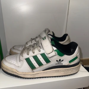 Adidas forum med gröna detaljer - Snygga vita Adidas sneakers med gröna och svarta detaljer. Använda mindre än 10 gånger, kan rengöras vid köp.