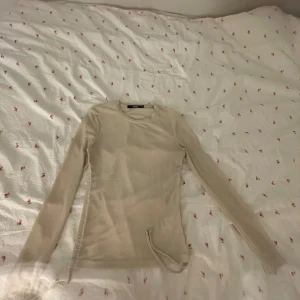Beige ribbad långärmad tröja BikBok - Säljer en beige långärmad tröja från BikBok i storlek XS. Tröjan är ribbad och har en rund halsringning samt en snygg snörningsdetalj på sidan. Perfekt att styla med jeans eller kjol för en chill look.
