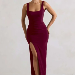 Vinröd långklänning med slits - Snygg vinröd långklänning med figurnära passform och breda axelband. Klänningen har en djup öppen rygg och en hög slits framtill som ger en extra touch. Perfekt för dig som vill sticka ut med en elegant och modern look. Storlek 6 uk 