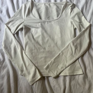 Vit långärmad topp med rund hals - En stilren vit långärmad topp med rundad urringning. Enkel och clean design som passar till allt. 