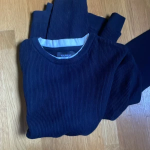 Mörkblå ribbad tröja Pull&Bear XS - Snygg mörkblå ribbad tröja från Pull&Bear i storlek XS. Tröjan har rund hals och långa ärmar, perfekt för dig som gillar enkel och stilren design. Materialet är mjukt och bekvämt, passar till jeans för en chill look.