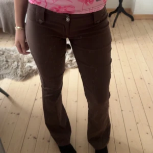 Lågmidjade bootcut kostymbyxor - Lågmidjade i brun färg. Helt oanvända (av mig). Jättesköna och så fina på. Säljer då de är för låga för mig och lite för små.