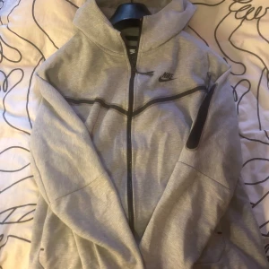 Grå Nike tröja  med huva - Nike tröja i storlek S men passar M bättre. Har använt några gånger.