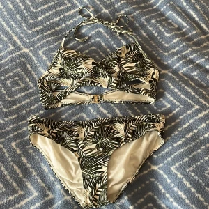 Grönvit bikini  - Snygg bikini i grönt och vitt. Överdelen har knyt i nacken och spänne i ryggen, medan underdelen är klassisk i modellen.💞