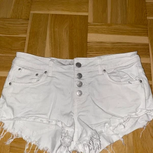 Vita jeansshorts från g perfect jeans - Snygga vita jeansshorts från g perfect jeans i storlek 36. Modellen är högmidjad med fransig kant nertill och knappar framtill. 