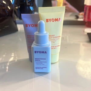 BYOMA hudvårdskit med serum och kräm - Säljer ett BYOMA hudvårdskit med tre produkter: Brightening Serum i ljusblå flaska med pipett, Moisturizing Rich Cream i lila tub och Creamy Jelly Cleanser i gul tub. Alla med Tri-Ceramide Complex och snygg minimalistisk design. Är bara lobbade en gång.