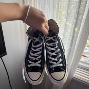 Svarta Converse Chuck 70 Taylor All Star - Svarta Converse Chuck Taylor All Star high-tops med vit sula och vita snören. De är i jätte bra skick, skriv för fler bilder eller frågor!🥰