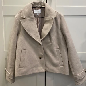 Beige kappa från Vila med stora slag -  beige kappa från Vila, storlek 40 men har vanligtvis 34. Valde dock att gå upp i storlek för att få mer oversized men är fof en kortare modell. Använd fåtal gånger 