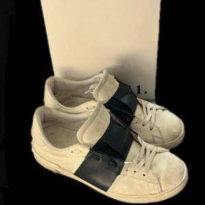 Valentino open - Upplev lyx och komfort med dessa ikoniska Valentino Garavani Open sneakers i klassisk vit och mörkblåa design. Tillverkade i äkta läder med exklusiv känsla och en stilren look som fungerar lika bra till jeans som till kostymbyxor.  ✅ Äkta Valentino Garavani (originalförpackning medföljer) ✅ Nypris ca 7 500 kr ✅ Bekväma och tidlösa – perfekt för både vardag och fest  Skick: Använda men i bra och fullt funktionellt skick. Lite patina och slitage på sulor och ovandel som ger dem karaktär.